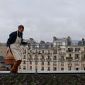 Мужчина держит корзину во время сбора урожая в саду на крыше Topager в Париже
