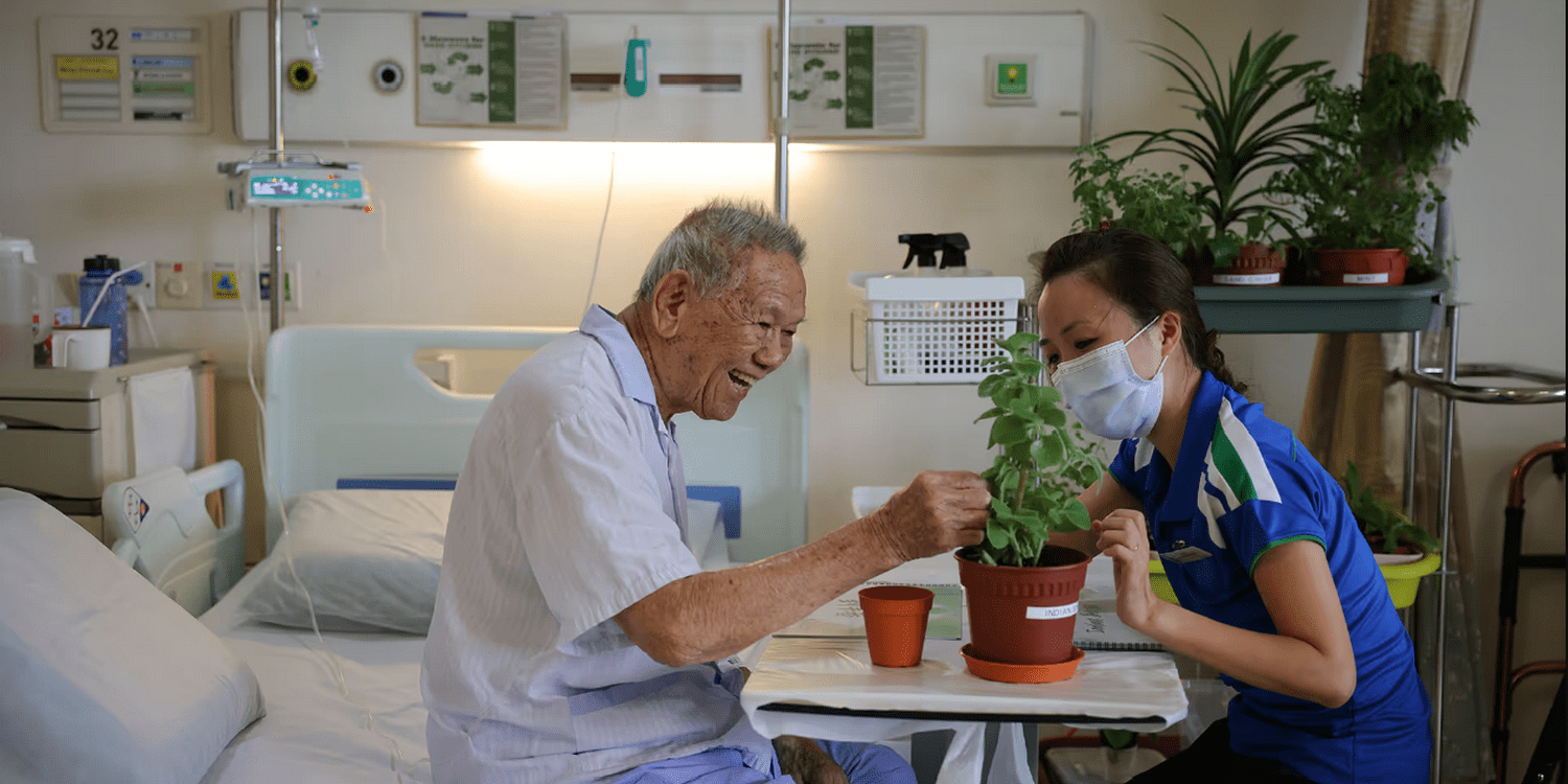 Эрготерапевт помогает пациенту больницы ухаживать за растением в палате