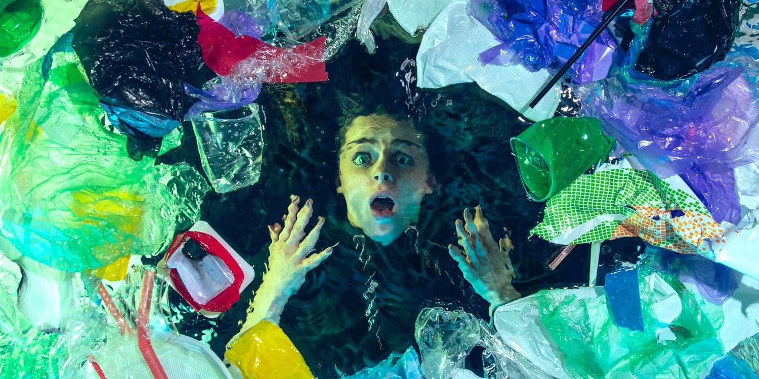 Девушка в ужасе смотрит на пластиковый мусор сквозь воду