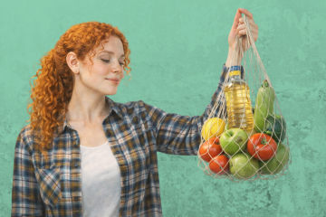 Девушка держит авоську со свежими овощами и фруктами