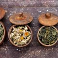 Четыре круглые деревянные коробочки с крышками с сухими лекарственными травами