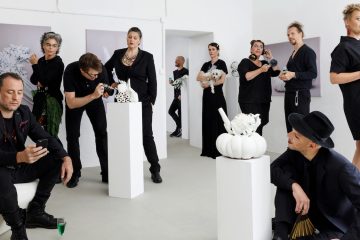 мужчины и женщины в черной одежде в помещении с белыми стенами