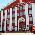 Здание Алтайского государственного аграрного университета, у входа стоит большой красный трактор
