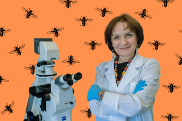 Женщина-учёный в белом халате стоит рядом с современным электронным микроскопом.