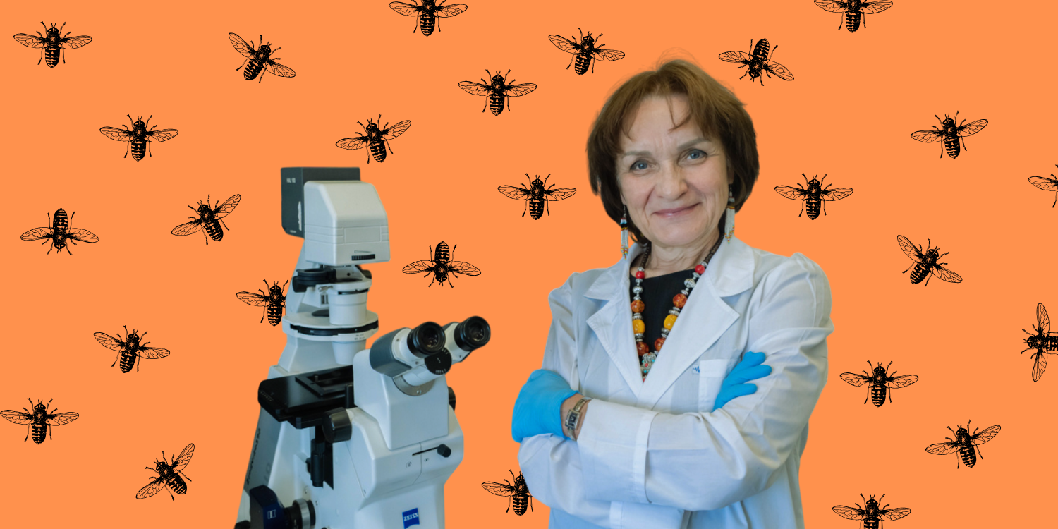 Женщина-учёный в белом халате стоит рядом с современным электронным микроскопом.