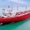Большой красный сухогруз плывёт по спокойному морю