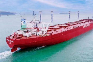 Большой красный сухогруз плывёт по спокойному морю