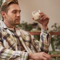 Мужчина пьет какао и работает с ноутбуком